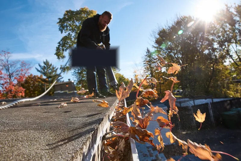 Gutter cleaning — clearing leaves and debris from a Michigan home gutter