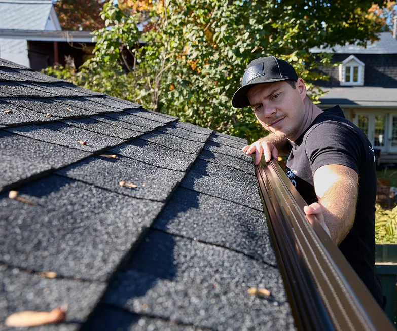 Installer setting a seamless gutter at the roofline