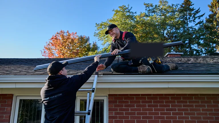 Lone Star Gutter Pros crew installing a seamless gutter run on a brick home